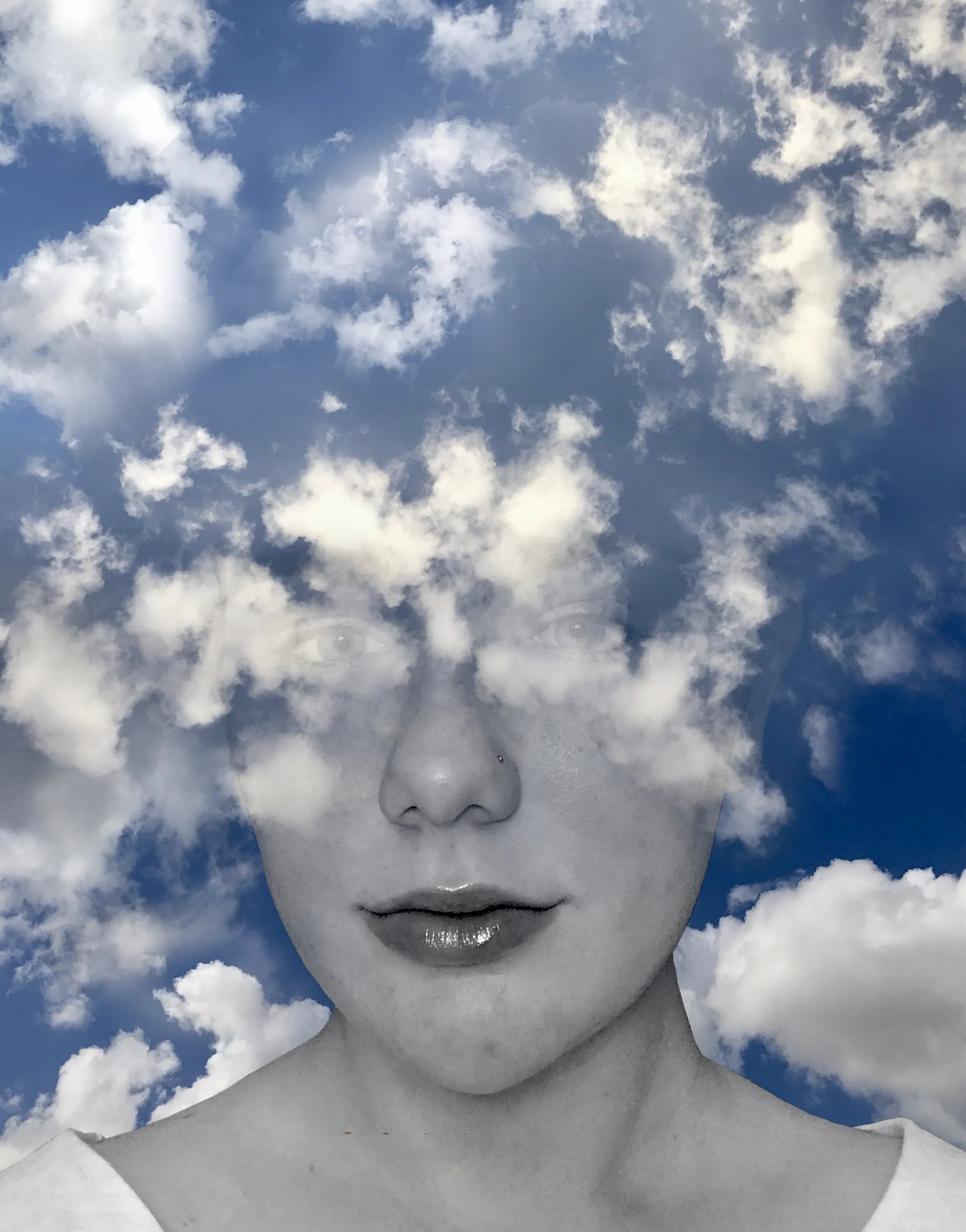 Conceptual portrait blending a face with a cloud-filled sky