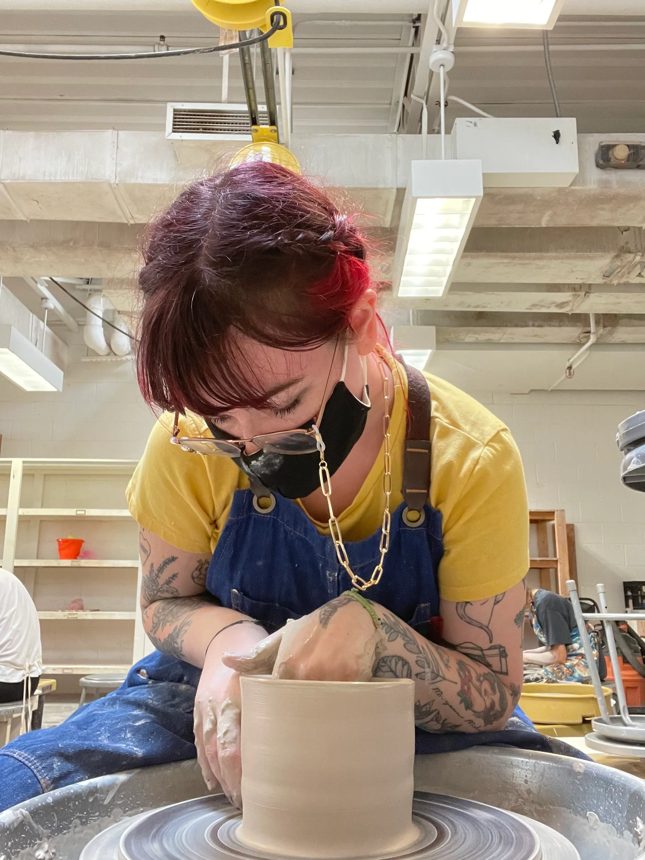 Devyn throwing a ceramic vessel on the wheel