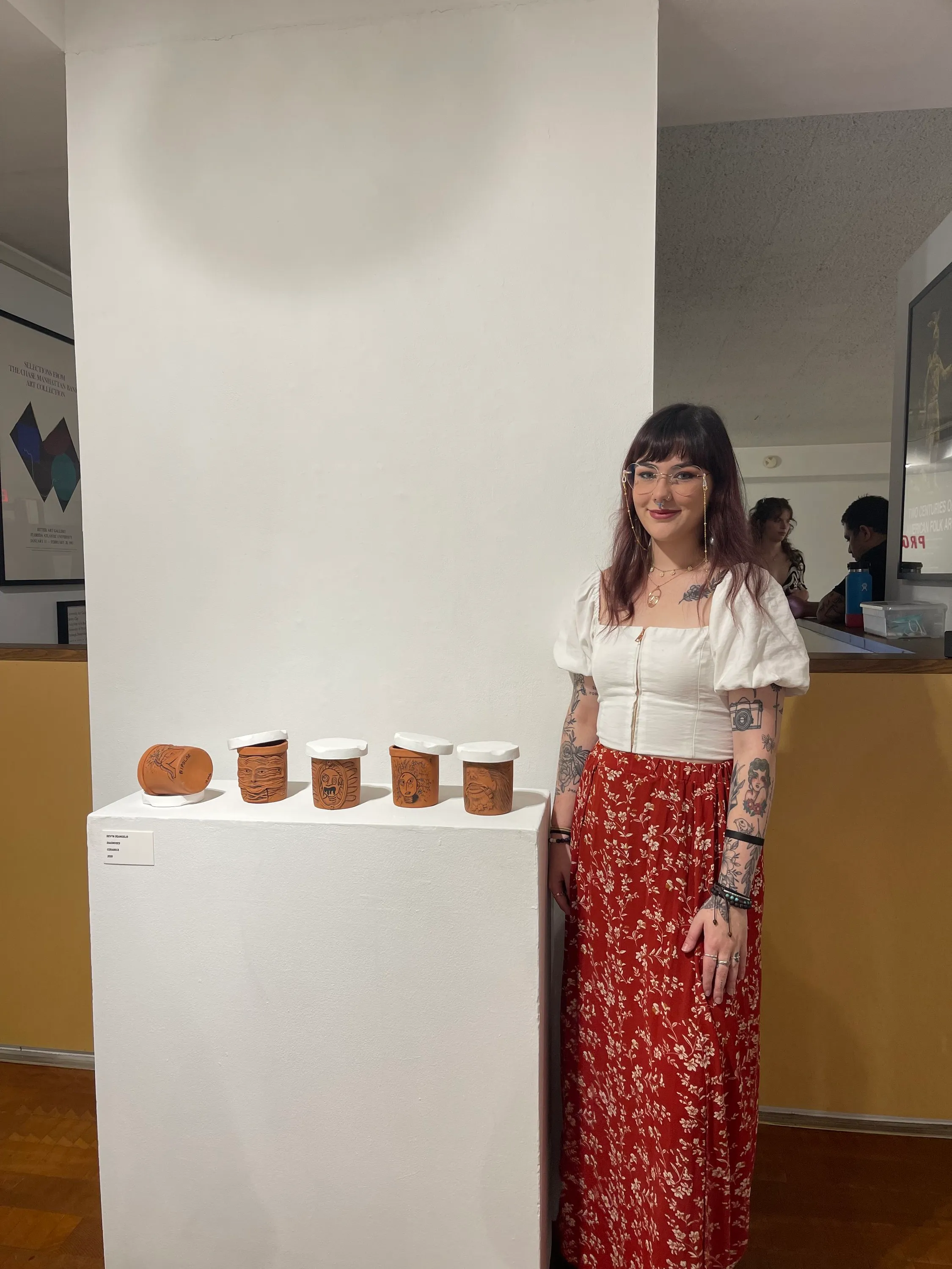 Devyn standing beside the Diagnoses ceramic series