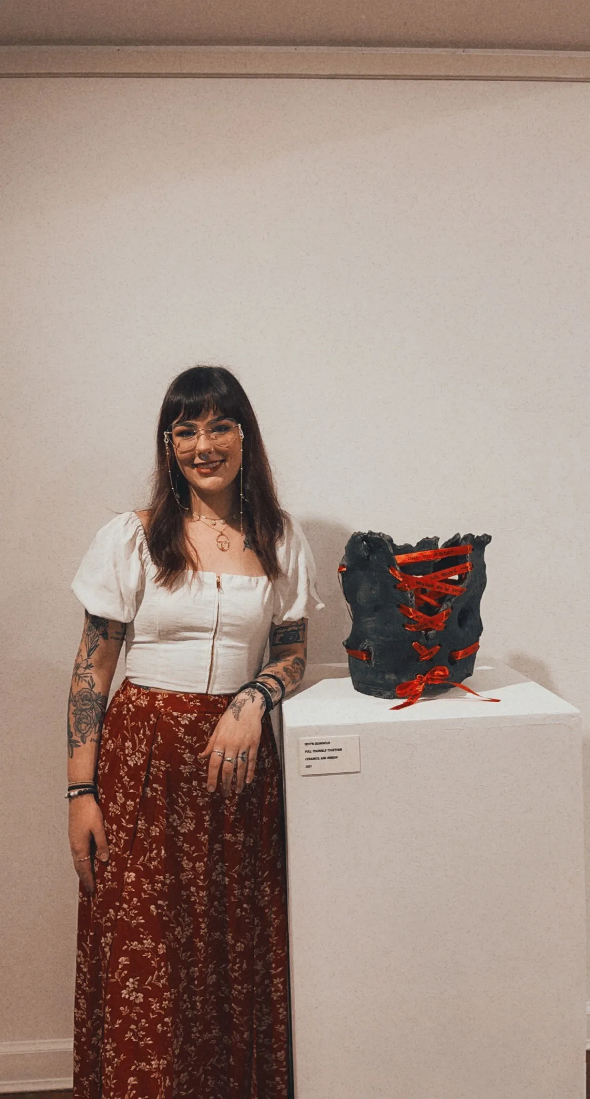 Devyn standing beside the ceramic sculpture Pull Yourself Together
