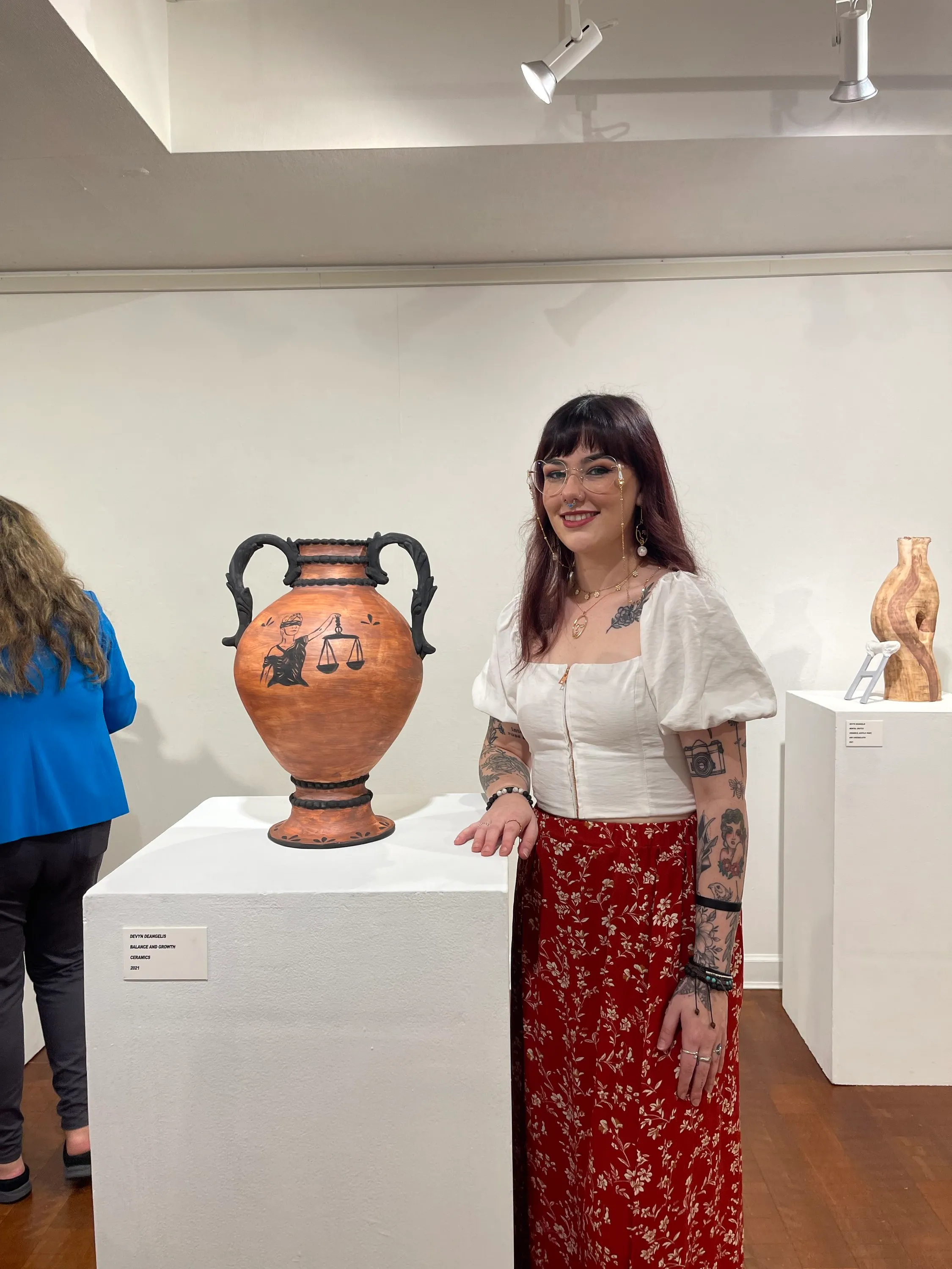 Devyn standing beside the ceramic sculpture Balance and Growth