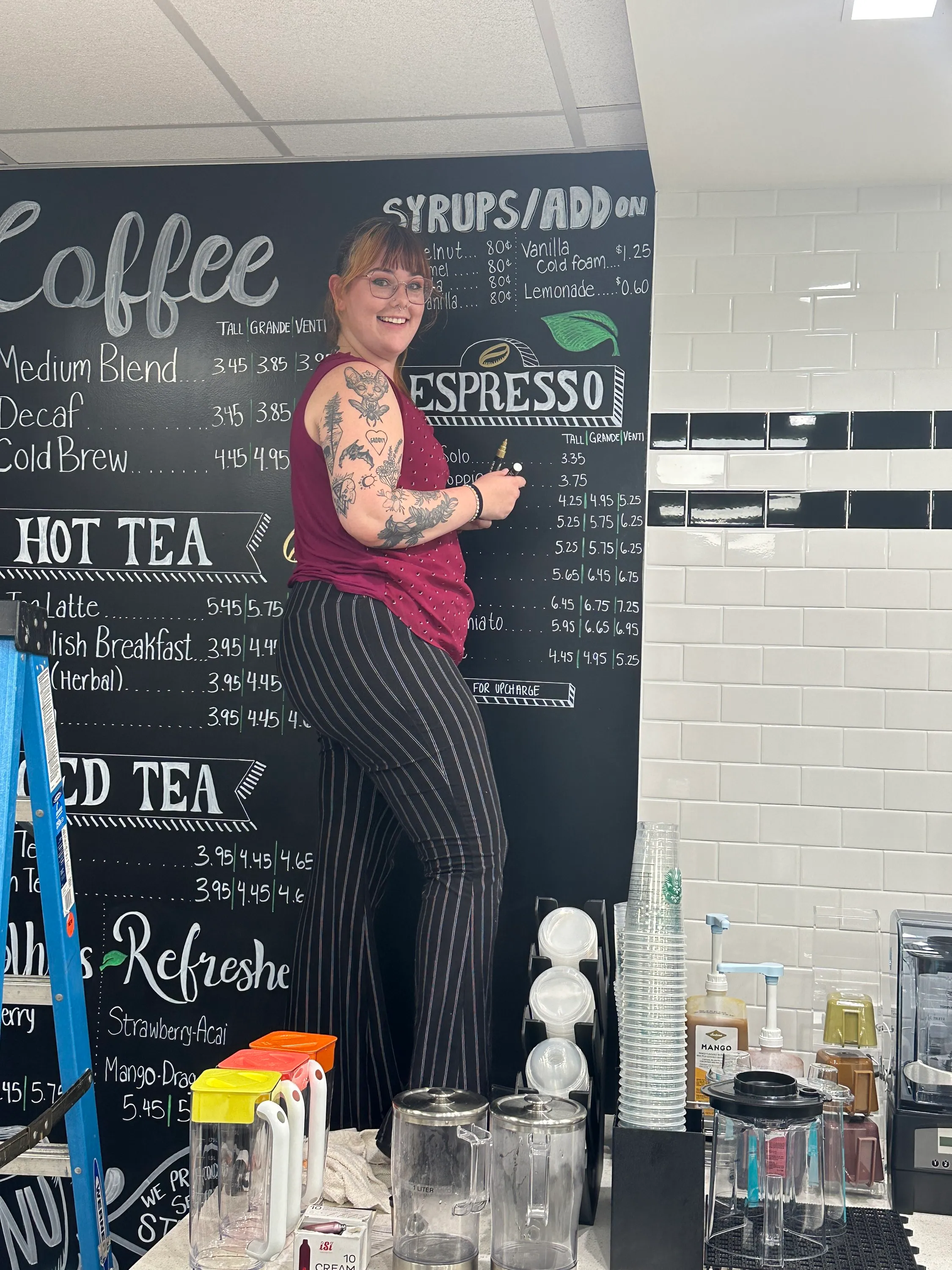 Devyn painting a café chalkboard mural