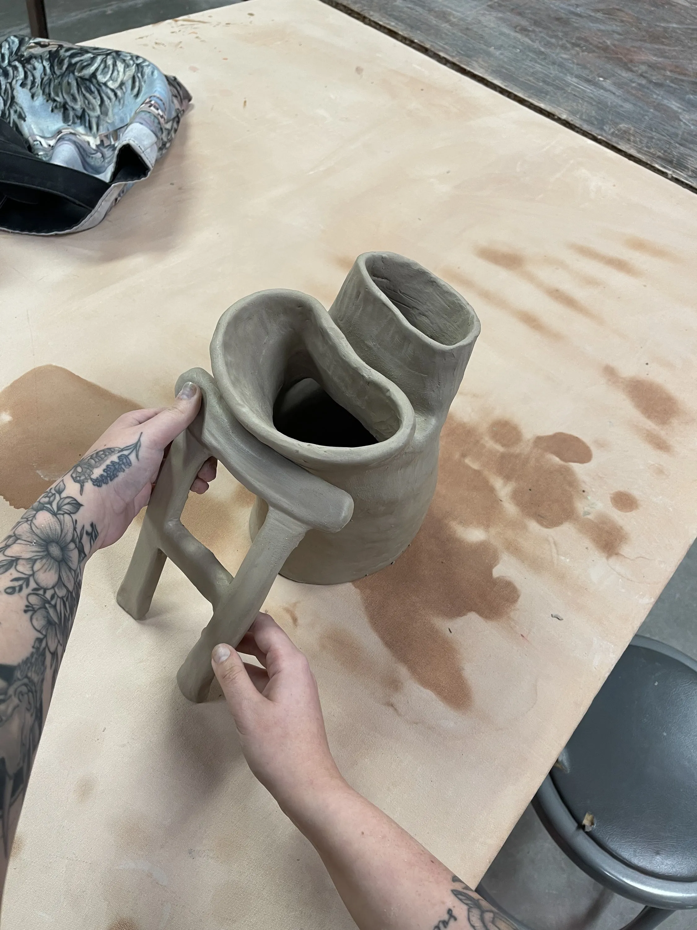 Hands shaping a small sculptural ceramic form
